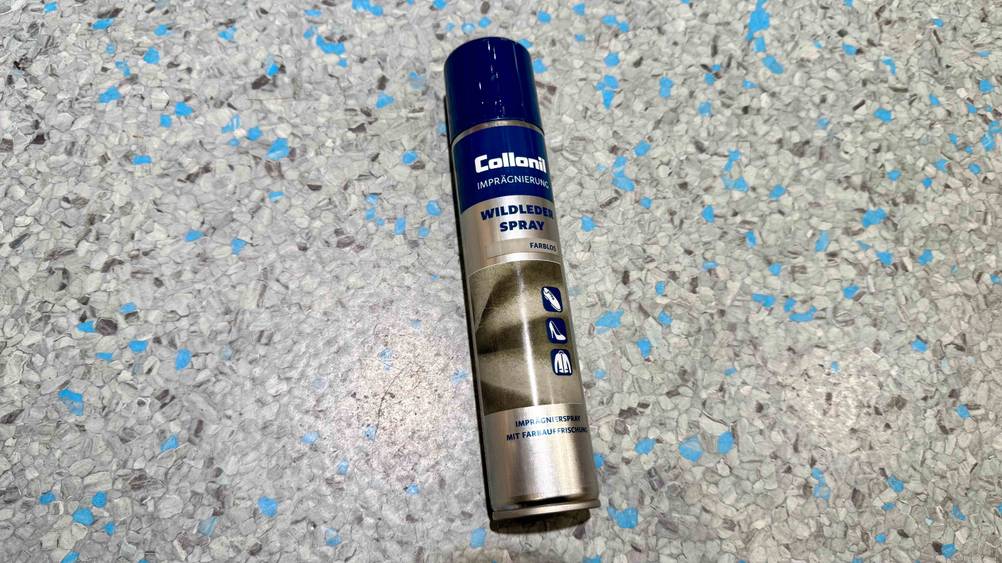 Eine Dose des getesteten Wildledersprays liegt auf einem grauen Boden.