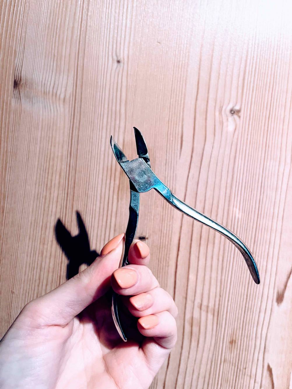 Eine Hand hält getestete Nagelhautzange von Wilkinson fest.