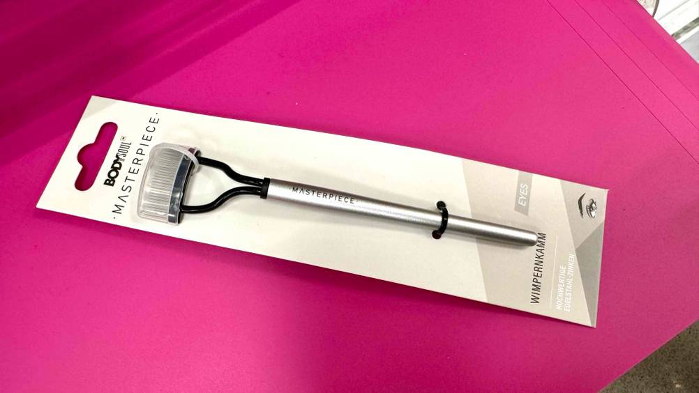 Getestet: Ein Wimpernkamm auf einer pinken Fläche liegend.