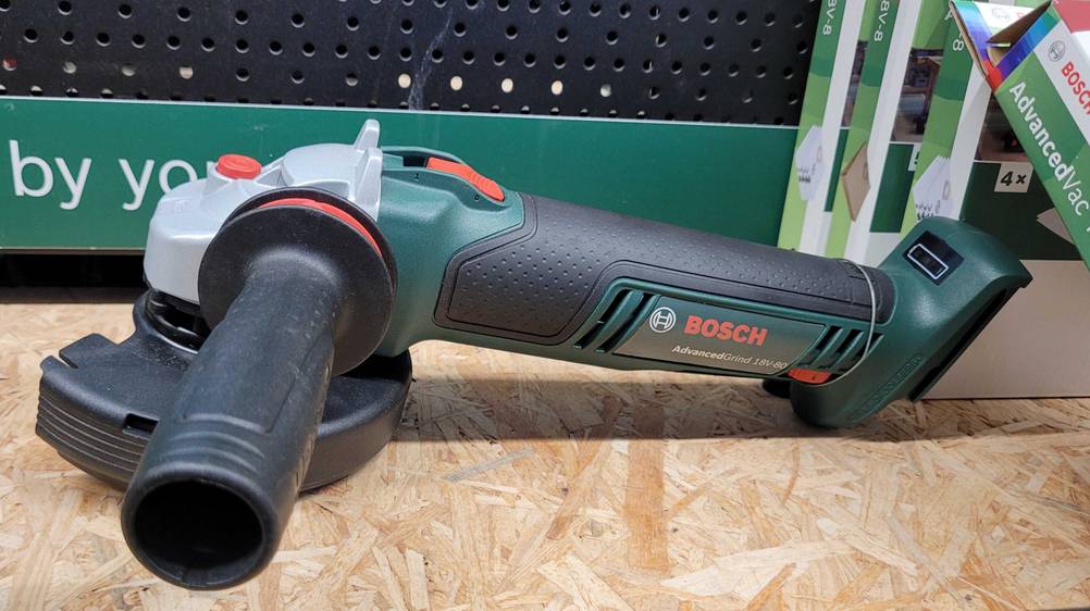 Getestet: Ein Winkelschleifer 125 mm mit Drehzahlregelung von der Seite auf einem Holzregal liegend.