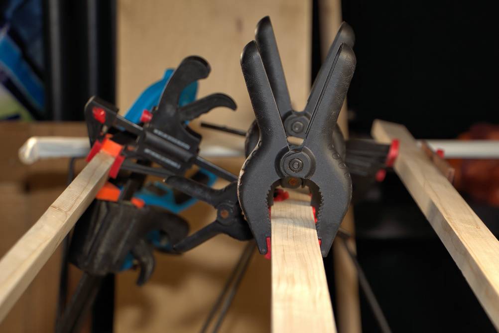 Winkelspanner im Test: Verschiedene Klemmen und Zwingen sowie Winkelspanner sind an Holzleisten fixiert.