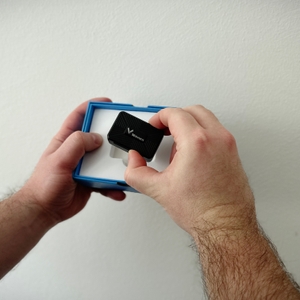 Ein Winnes TK913 wird aus einer blauen Box entnommen. Das Gerät liegt in einer weißen Einlage im Inneren.