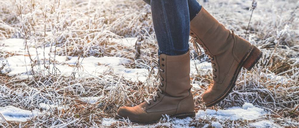 Winterstiefel Damen-Test: Frau mit Winterboots geht auch leicht schneebedecktem Naturboden.