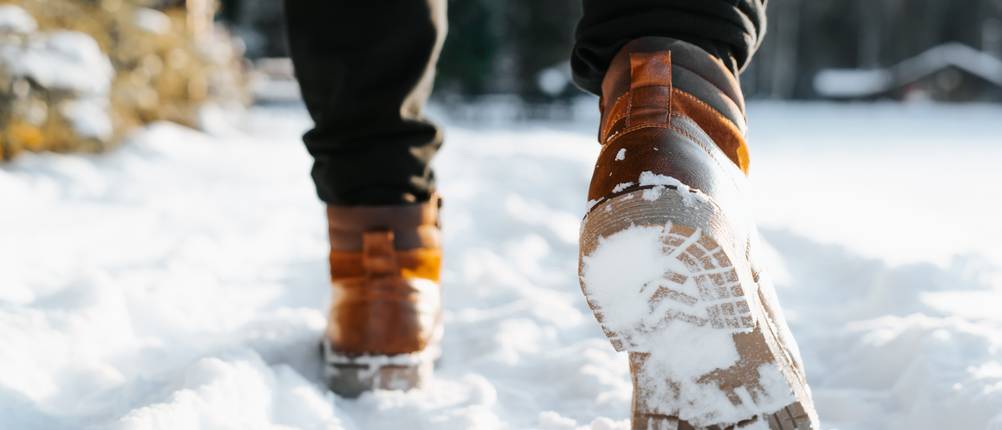 Winterstiefel Herren-Test: Mann mit Winterstiefeln geht im Schnee