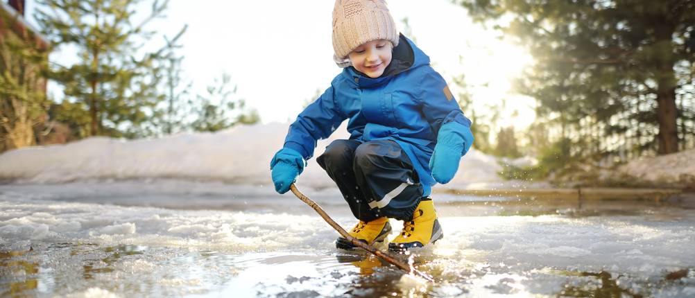 winterstiefel-kinder-jungen Test: Kind spielt mit Stock im Schnee
