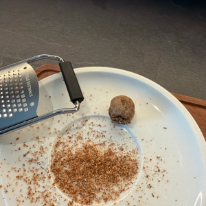 Eine teilweise geriebene Muskatnuss liegt neben der Winzbacher KS-0039