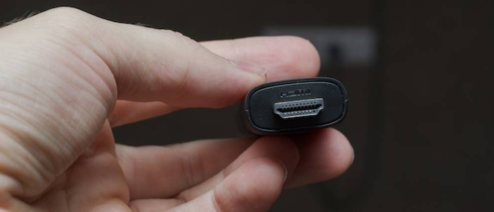 Wireless-HDMI-Test: Eine Hand hält einen HDMI-Anschluss.