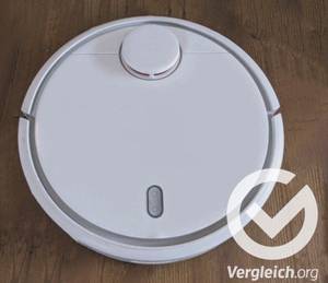 Ein weißer Wischroboter im Test steht auf Parkett.