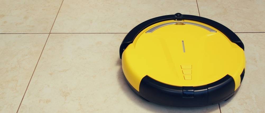 Wischroboter von iRobot im Test: Ein gelber iRobot-Wischroboter reinigt beigefarbene Fliesen.