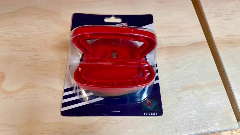 Saugheber getestet: Ein Gerät von unten in der transparenten Verpackung auf einer Holzfläche.