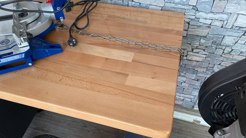 Draufsicht Holz-Werkbank im Test. Auf der robusten Arbeitsfläche befindet sich ein elektrisches Schneidewerkzeug.