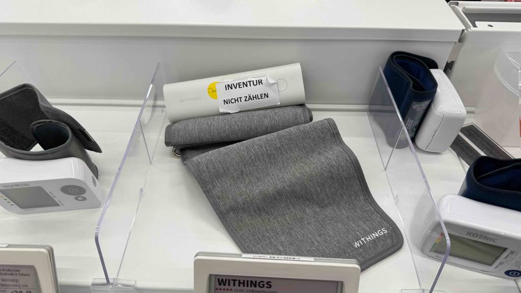 In einem Ausstellungsbereich liegt ein getestetes Bluetooth-Blutdruckmessgerät inklusive Manschette.
