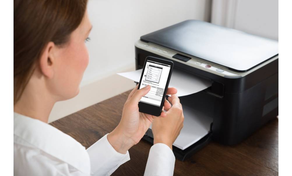 Frau richtet getesteten Epson-A3-Drucker über das Smartphone ein.