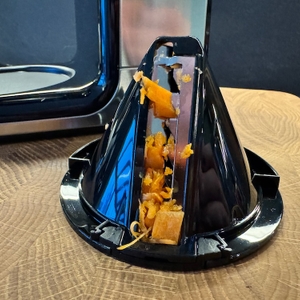 Karottenstücke stecken im Schneidaufsatz des Spiralschneiders.