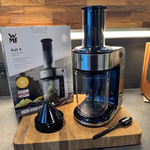 Der WMF Kult X Spiralschneider steht aufgebaut auf einem Holzbrett.