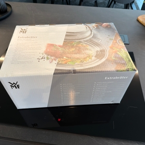 Der Karton vom Wmf 0788009990 steht auf einer Kochplatte