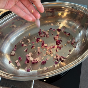 Eine Hand gibt Zwiebeln in den Wmf 0788009990