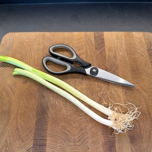 Zwei Frühlingszwiebeln liegen neben der WMF 18.7920.6100