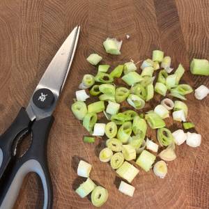 Geschnittene Frühlingszwiebeln liegen neben der WMF 18.7920.6100