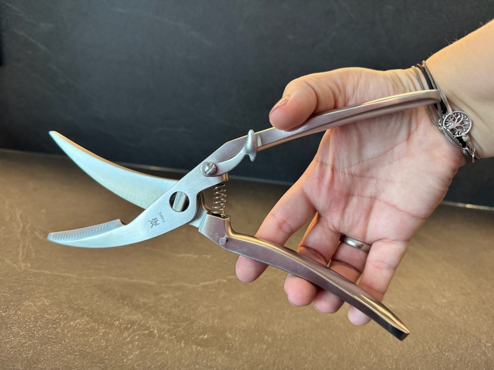 Eine Hand hält die WMF-1887719990-Geflügelschere fest