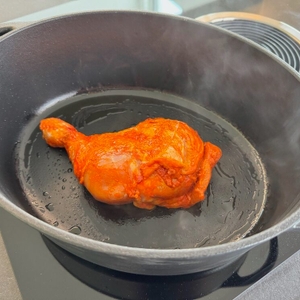 Ein Stück Fleisch liegt während dem Braten auf dem Herd im WMF 571464290