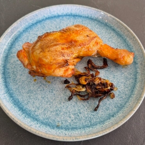 Auf einem Teller liegen ein Stück Fleisch und Zwiebeln