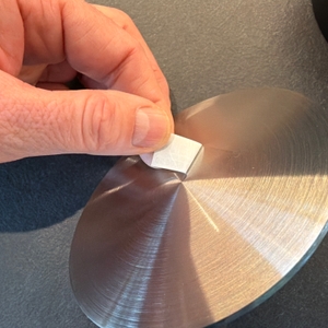 Eine Hand zieht einen Aufkleber von der Wmf-BBQ-Burgerpresse 690296030