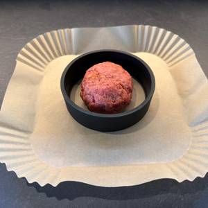 Ein Fleischbällchen liegt in der Wmf-BBQ-Burgerpresse 690296030