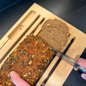 Brot wird mit einem Messer auf dem WMF-Brotschneidebrett geschnitten