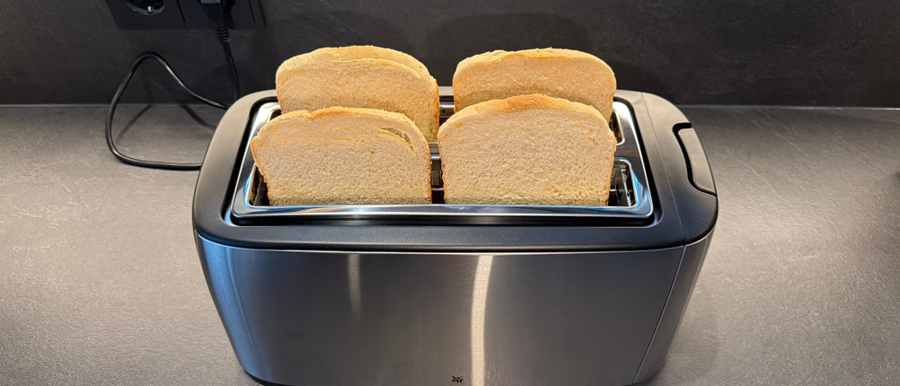 Vier Toastscheiben liegen im WMF-Bueno-Pro-Toaster