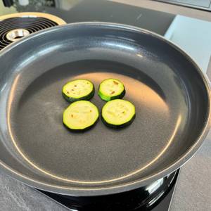 Vier Zucchinischeiben liegen in der WMF-Devil-Bratpfanne