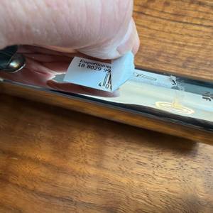 Eine Hand zieht einen Aufkleber vom Griff vom Wmf-Eisportionierer