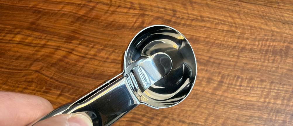 Eine Hand drückt den Hebel am Wmf-Eisportionierer