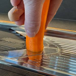 Karotte in der Hand, die mit dem WMF-Gemüsehobel Top Tools geschnitten wird