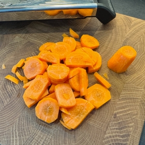 Fertige Karottenscheiben auf einem Holzbrett, nachdem sie mit dem WMF-Gemüsehobel Top Tools geschnitten wurden