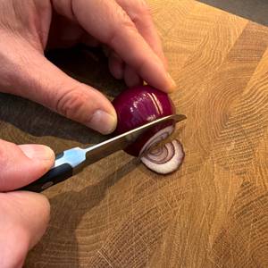 Mit dem Wmf-Gemüsemesser wird eine Zwiebel geschnitten