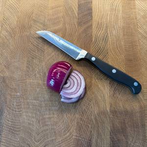 Das Wmf-Gemüsemesser liegt neben einer zur Hälfte geschnittenen Zwiebel