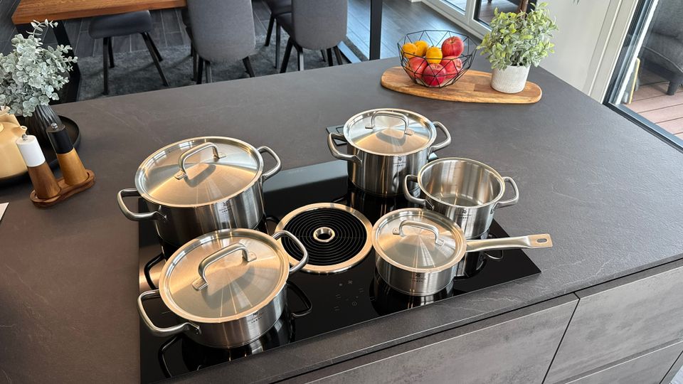 Fünf Töpfe vom Set WMF Gourmet Plus auf dem Induktionsherd.