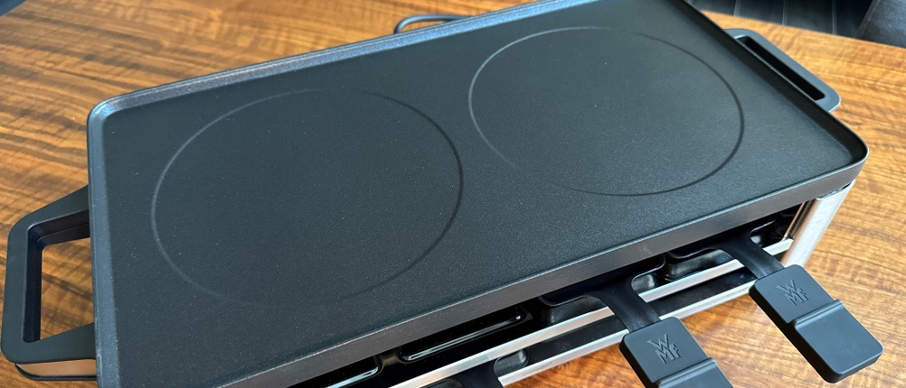 Die Grillplatte liegt mit der glatten Seite nach oben auf dem WMF LONO 415040011.