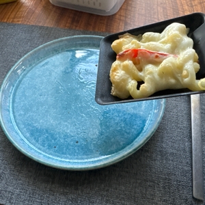 Mit Käse überbackene Nudeln werden mit einem Raclettespachtel aus einer Pfanne des WMF LONO 415040011 entfernt.