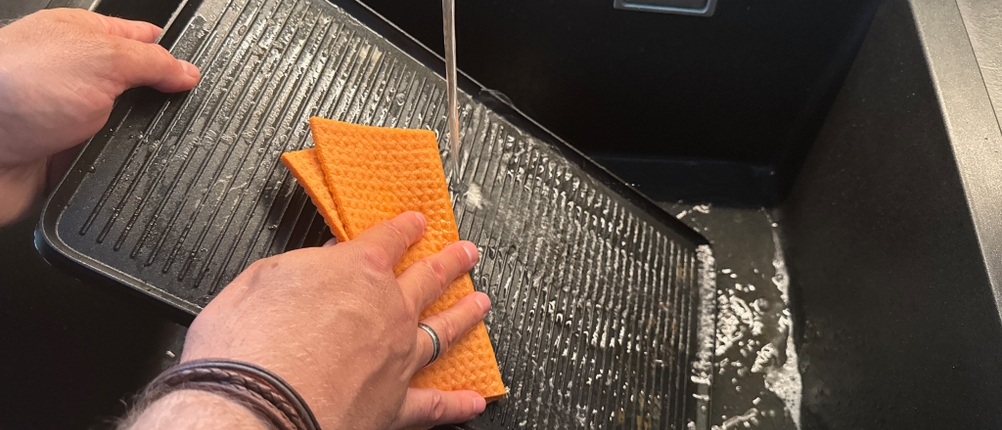 Die Grillplatte des WMF LONO 415040011 wird mit einem Lappen gereinigt.