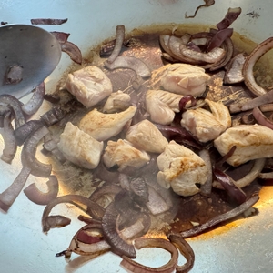 Hähnchen und Zwiebeln werden in der WMF-Party-Taiwan-Wokpfanne angebraten