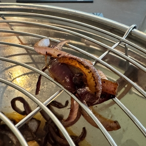 Zwiebeln rutschen durch das Grillrost der WMF-Party-Taiwan-Wokpfanne