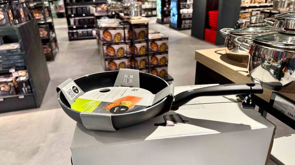Auf dem Originalkarton steht eine WMF-Pfanne im Test in einem Verkaufsladen.