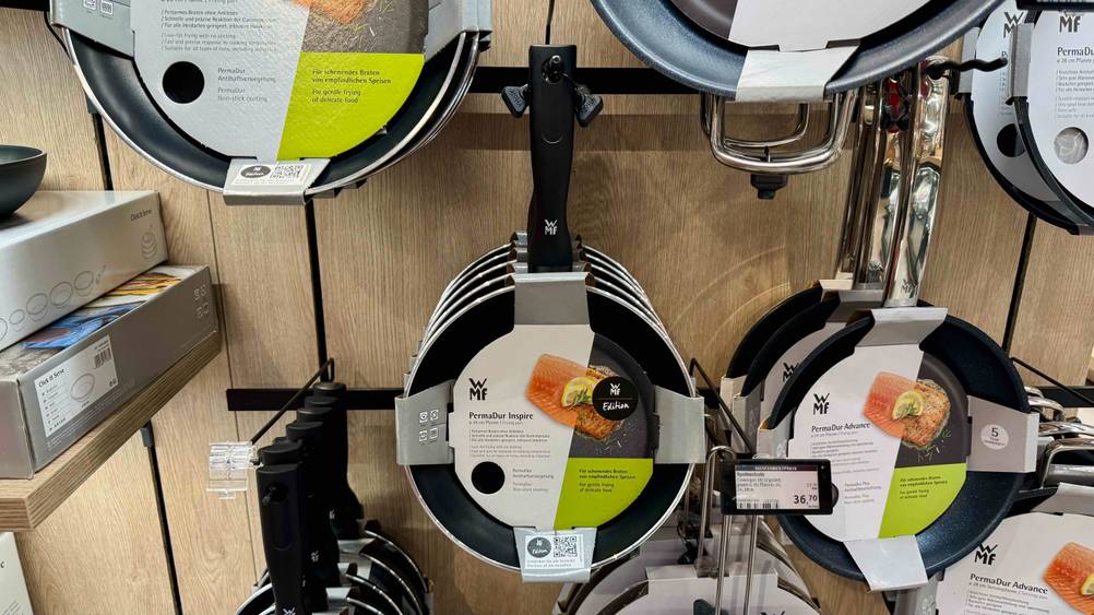 In einem Verkaufsregal hängen mehrere getestete WMF-Pfannen.