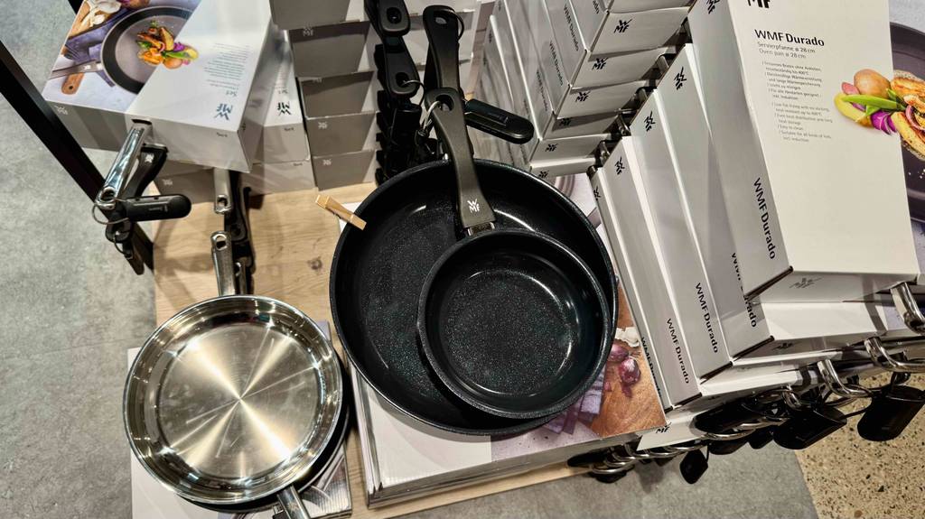 Im Test: Blick von oben auf ein WMF-Pfannenset, das auf Verpackungskartons steht.