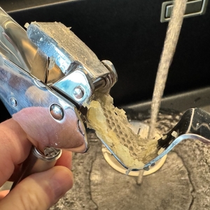 Nahaufnahme der WMF Profi Plus, die von einer Hand unter einen Wasserstrahl gehalten wird.