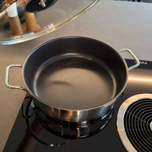 Die Wmf-Schmorpfanne 28 cm steht ohne Deckel auf einer Kochplatte