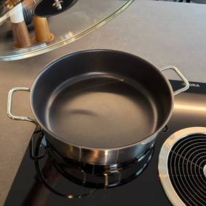Die Wmf-Schmorpfanne 28 cm steht ohne Deckel auf einer Kochplatte