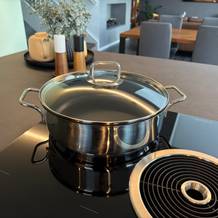 Die Wmf-Schmorpfanne 28 cm steht mit Deckel auf einer Kochplatte